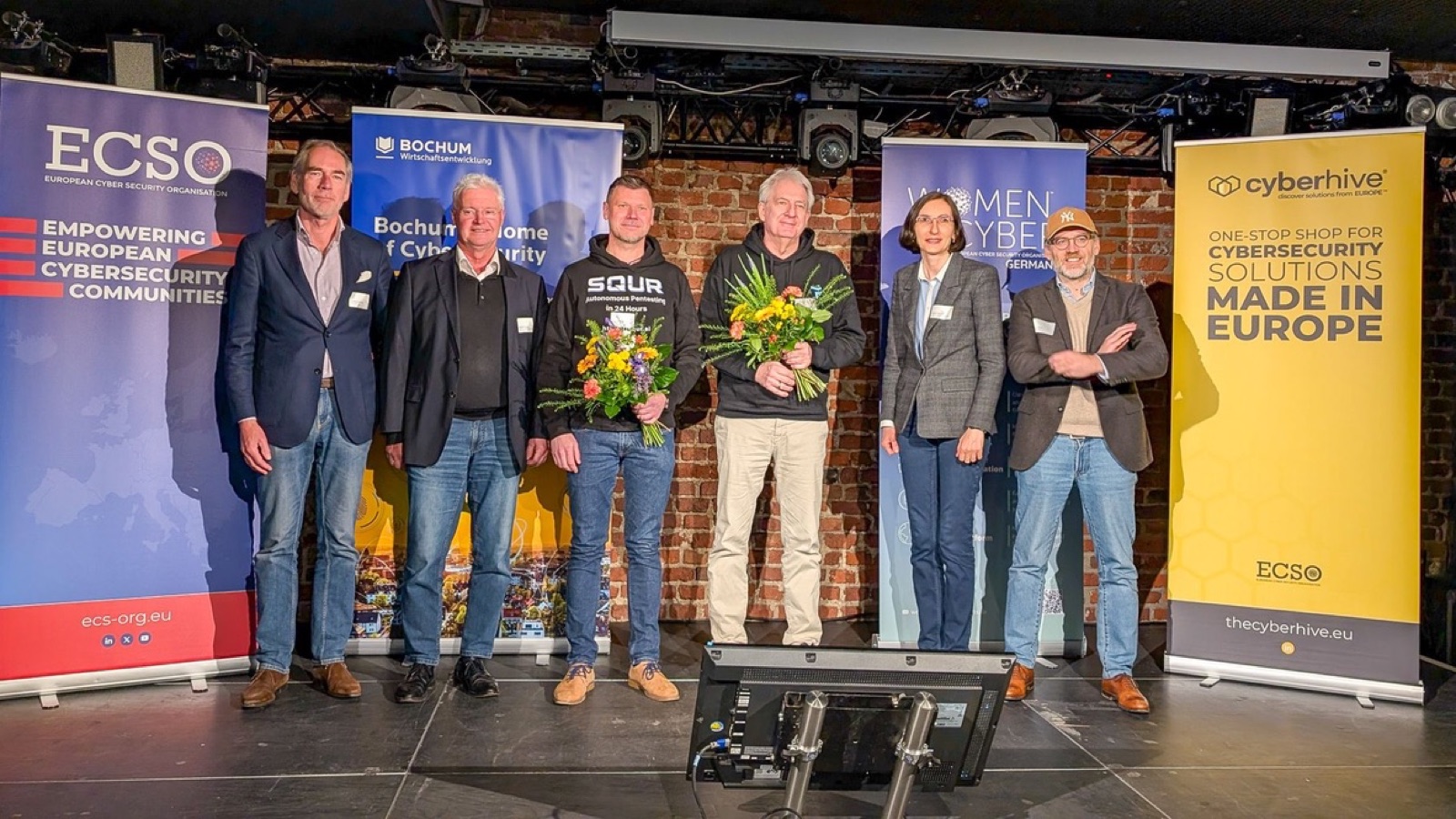Award recipients of the ECSO STARtup Award qualifier on stage in Bochum, with ECSO, Bochum Wirtschaftsentwicklung, Women4Cyber Germany and CyberHive banners